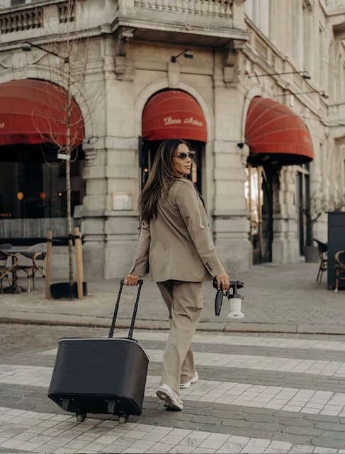 Gigi on an Antwerp street with her spray tan equipment and suitcase