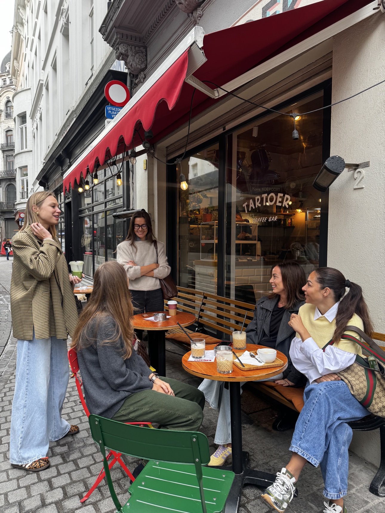 Friends gathered around café tables on a European street