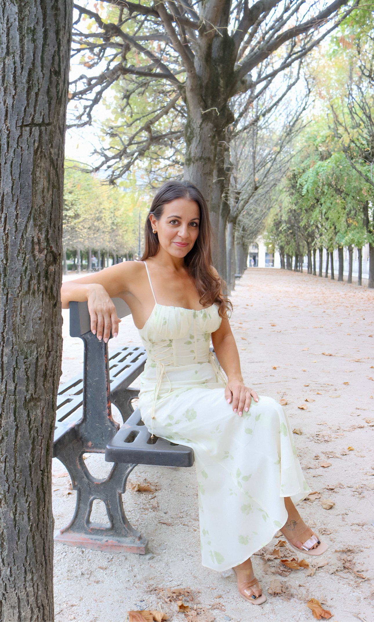 Jenn seated on a garden bench in Paris